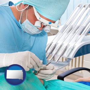 an oral surgeon operating on a dental patient - with South Dakota icon