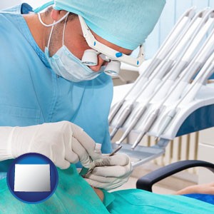 an oral surgeon operating on a dental patient - with Wyoming icon